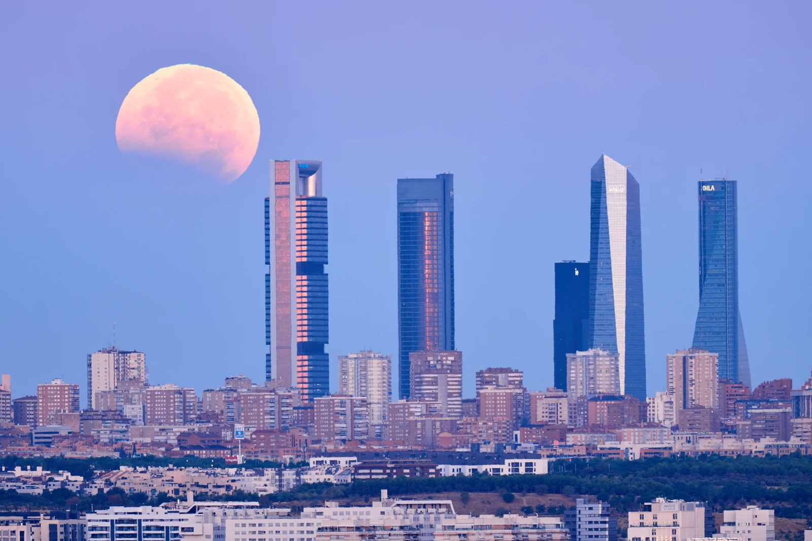 Partial lunar eclipse above a skyline.