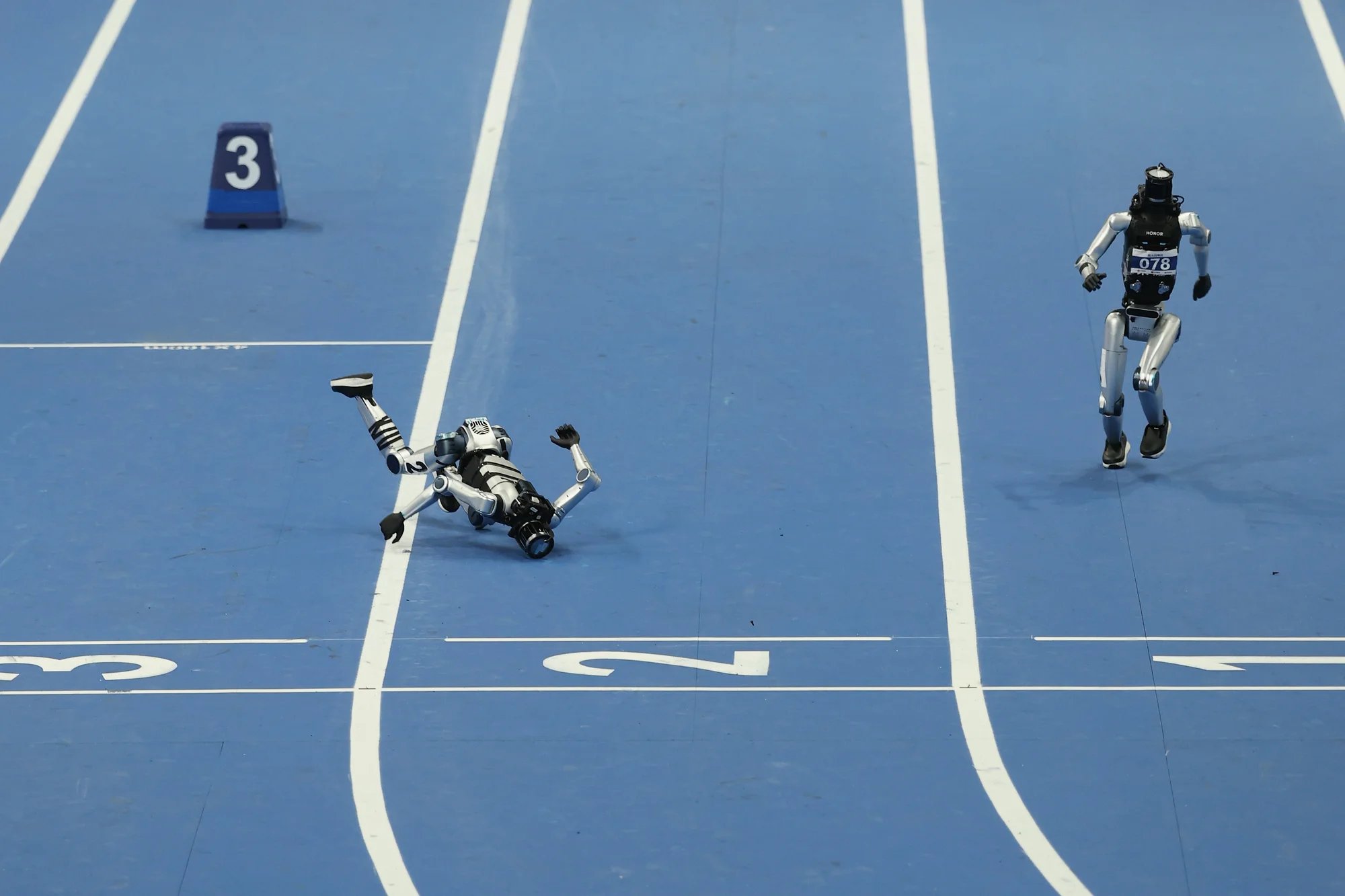 Humanoid robots race, and one falls down.