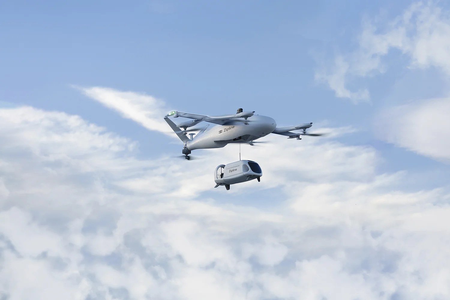 Aerial photo provided by Zipline of it's drone plane carrying the land drone for deliveries.