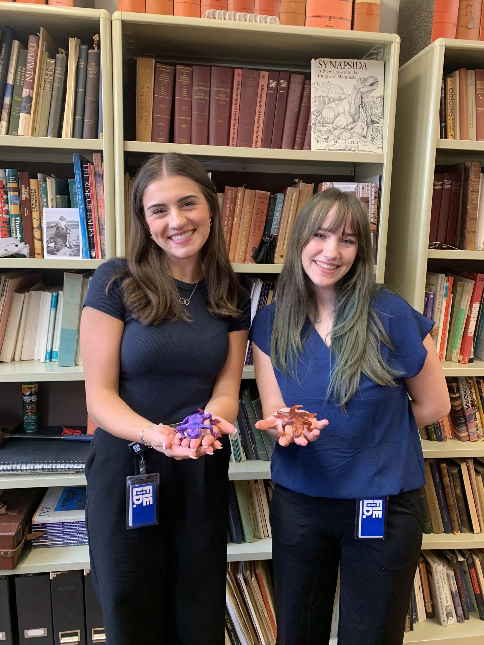 two women holding a model of a salamander