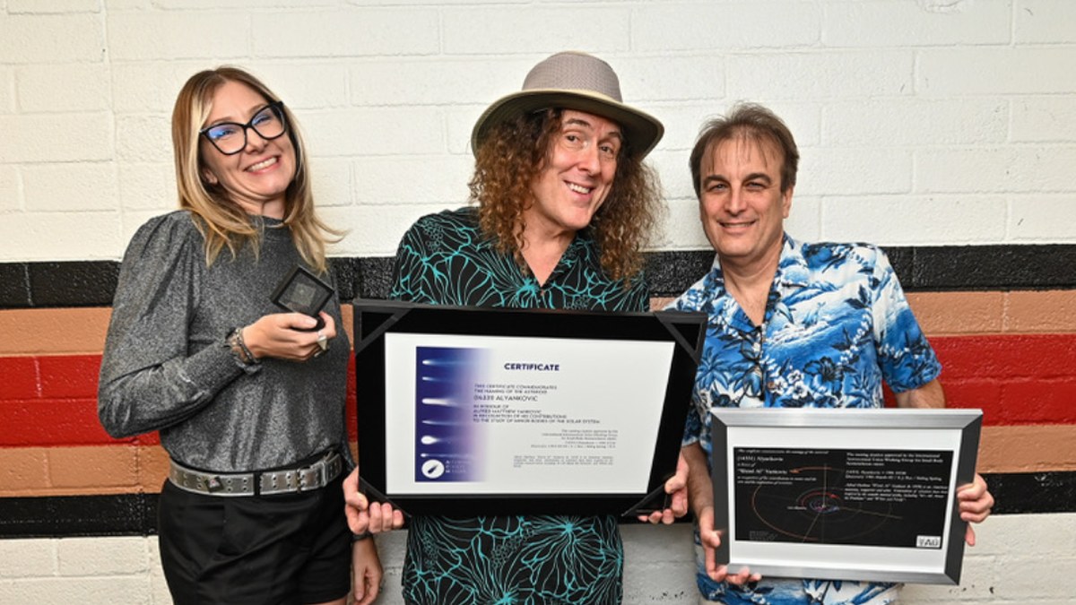 Dr. Allison McGraw, Al Yankovic, AND Dr. Steve Desch. stand against a wall. Al is holding a framed certificate