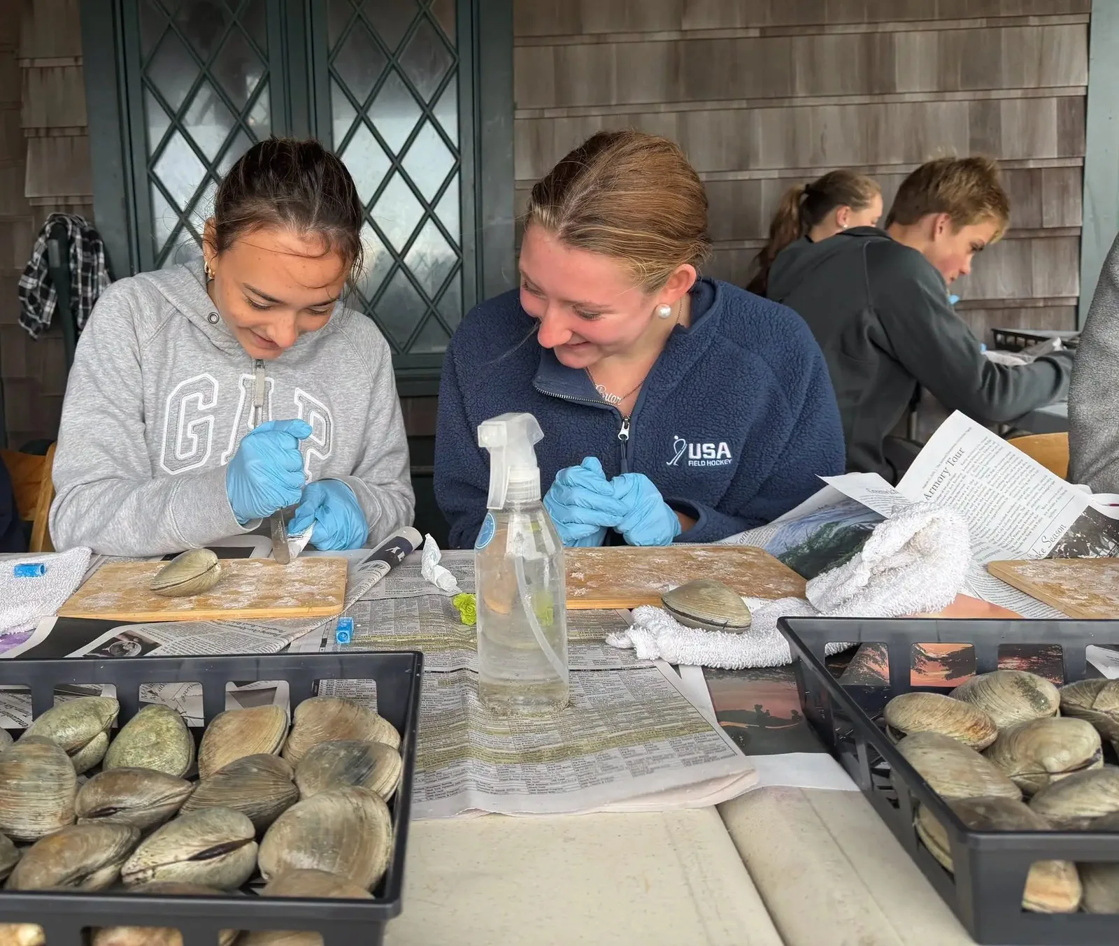 two students wearing gloves working on a clam shell
