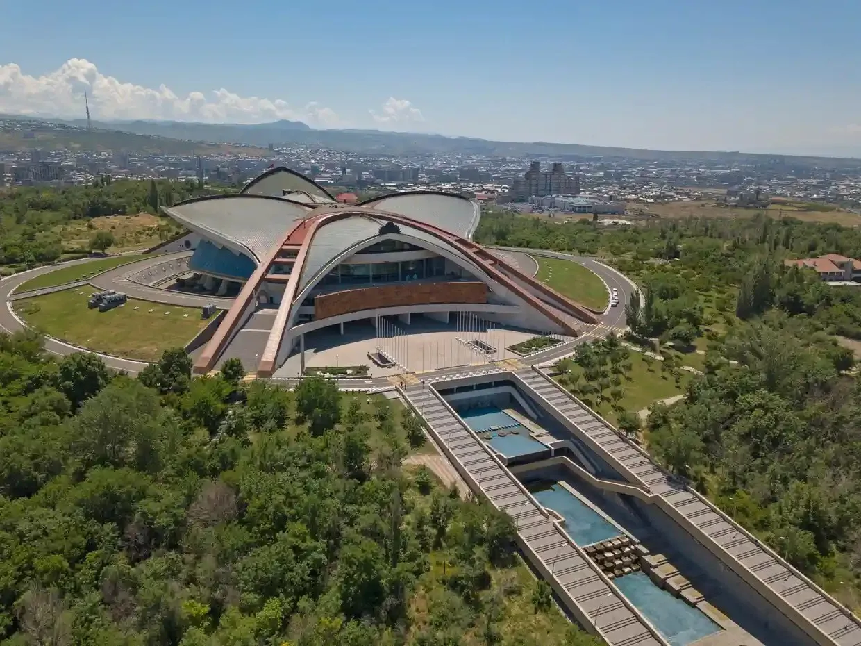 A modern conference building surrounded by trees. 
