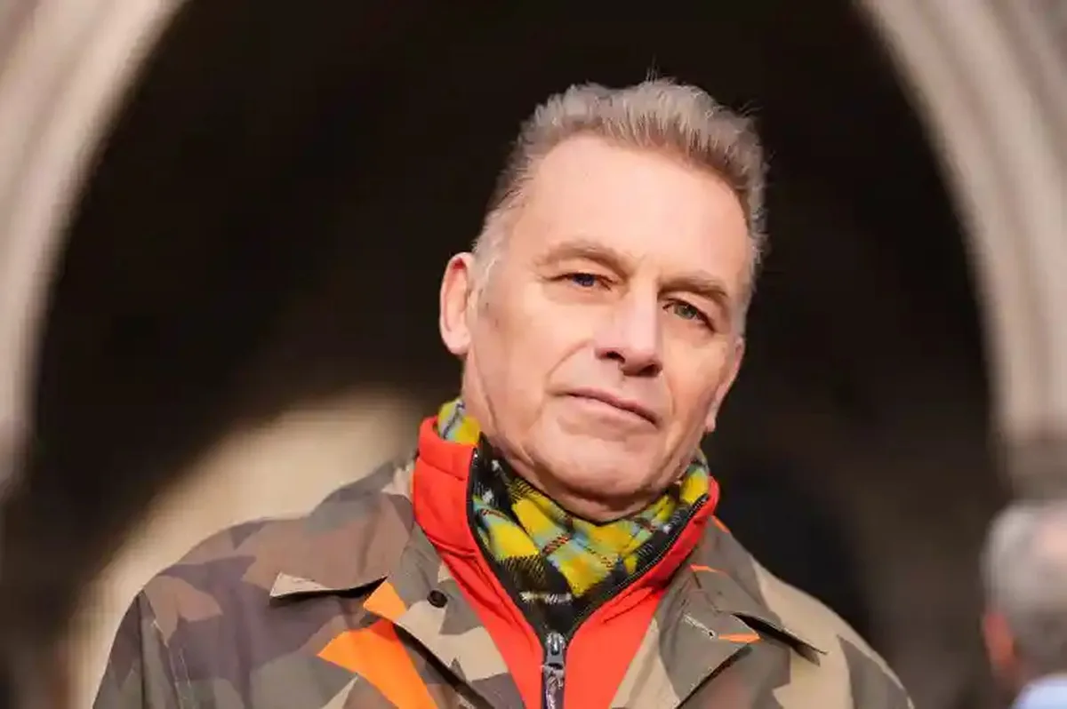 Chris Packham wears a camouflage jacket and plaid scarf outside the Royal Courts of Justice