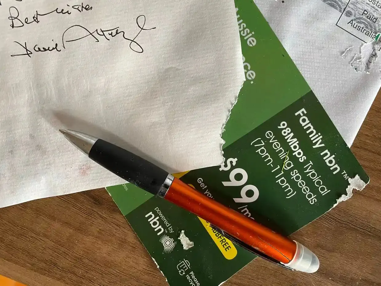 A pen rests on a letter from Sir David Attenborough, its corner chewed away by snails. 