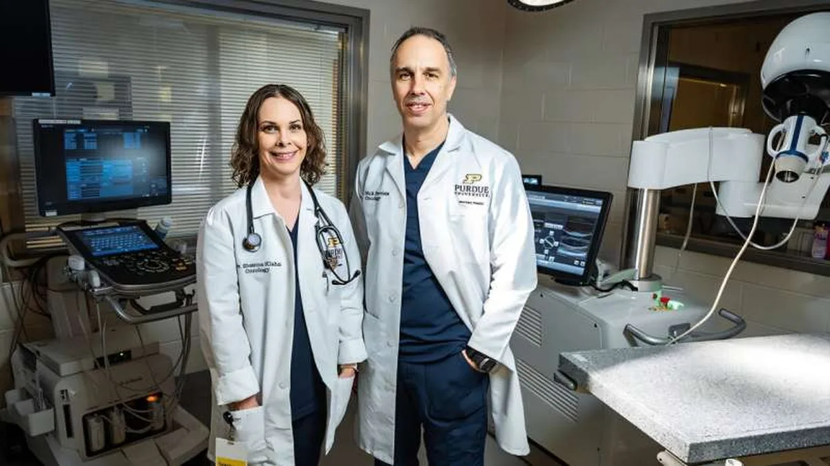 Two comparative oncologists stand in a veterinary lab room.